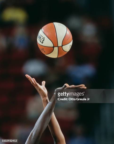 Detail view of two basketball players reaching for the Splading basketball at the tip off during the WNBA Western Conference basketball game between...
