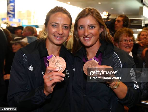 Rebecca Scown and Juliette Haigh of the New Zealand Olympic team display their Bronze Medals after arriving at Auckland International Airport after...