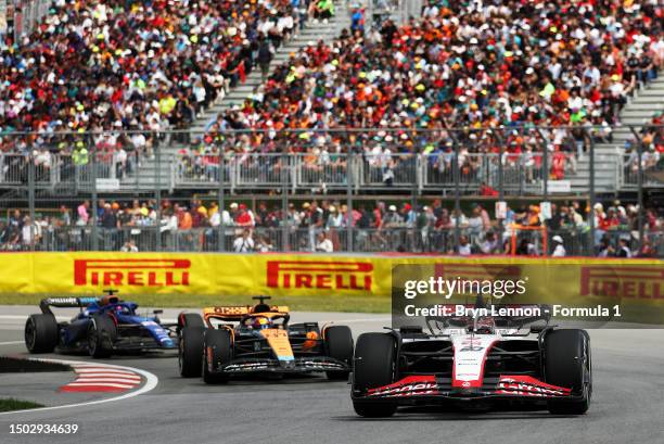 Kevin Magnussen of Denmark driving the Haas F1 VF-23 Ferrari leads Oscar Piastri of Australia driving the McLaren MCL60 Mercedes on track during the...