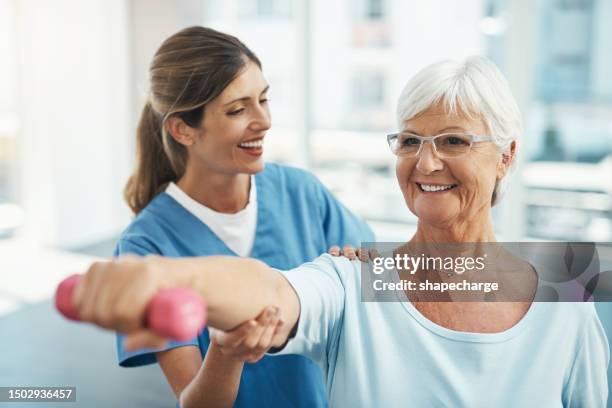 senior woman, doctor and helping in weightlifting for physical exercise or activity at the hospital. happy nurse, therapist or physician assisting elderly lady in workout or training at the clinic - senior people training imagens e fotografias de stock