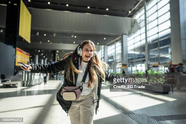 young woman dancing at the airport - facial expression stock pictures, royalty-free photos & images