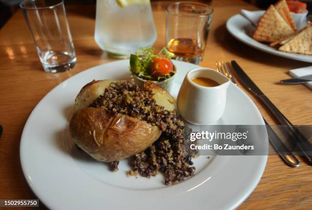 haggis with baked potato, salad, and whisky sauce in dunoon, scotland, on may 6th, 2023. - haggis stock-fotos und bilder