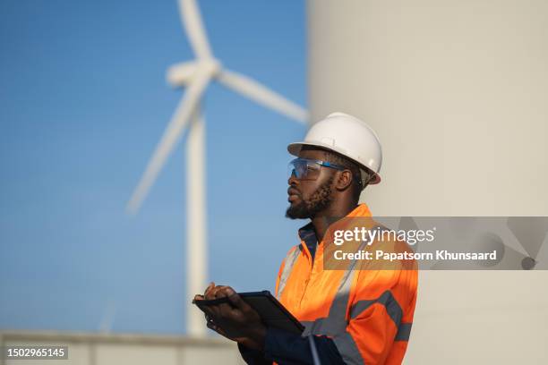 engineer man using tablet for windturbine sustainable energy generator project. - wind generator stock pictures, royalty-free photos & images