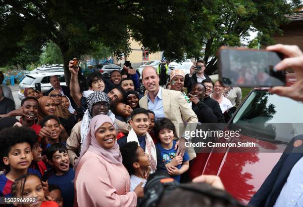 Prince William, Prince of Wales poses for a photo with members of the public during a visit to Reach Up Youth at the Verdon Recreation Centre on June...