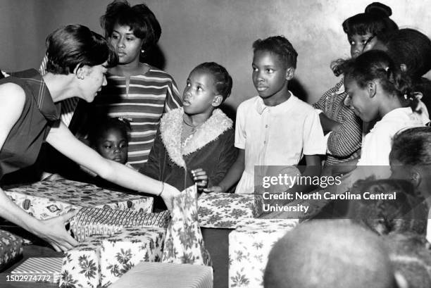Valerie Spaulding of Greensboro, North Carolina., and Peggie Benton of Monticello, GA., give Christmas gifts to children who attended a Christmas...