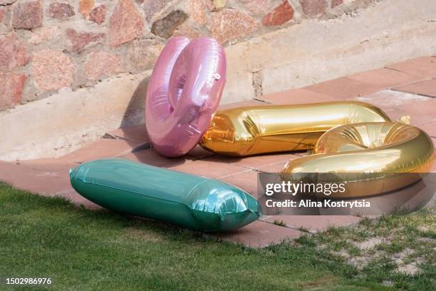 multicolored number balloons lie in backyard - cleaning after party - fotografias e filmes do acervo