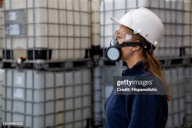 travailleur d’une usine chimique portant un masque à gaz et des vêtements de travail de protection - substances dangereuses photos et images de collection
