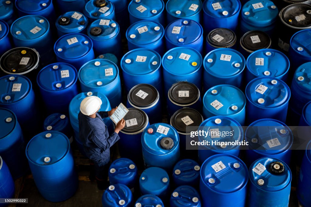 Arbeiter, der während der Arbeit in einer Chemiefabrik eine Inventur durchführt