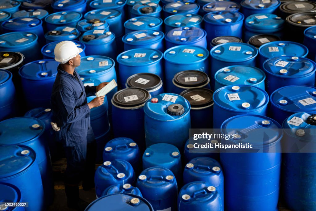 物流倉庫で樽の在庫棚卸を行う化学プラント作業員