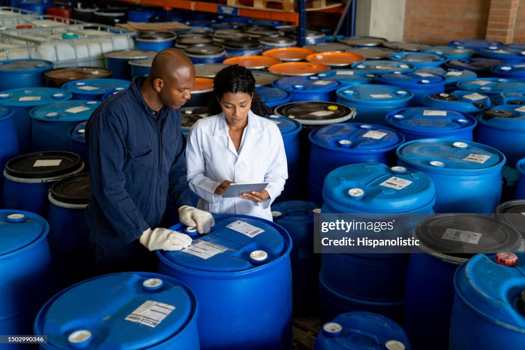 Foreperson talking to a blue-collar worker at a chemical plant
