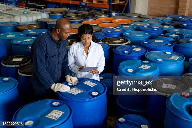 foreperson talking to a blue-collar worker at a chemical plant - drum container stock pictures, royalty-free photos & images