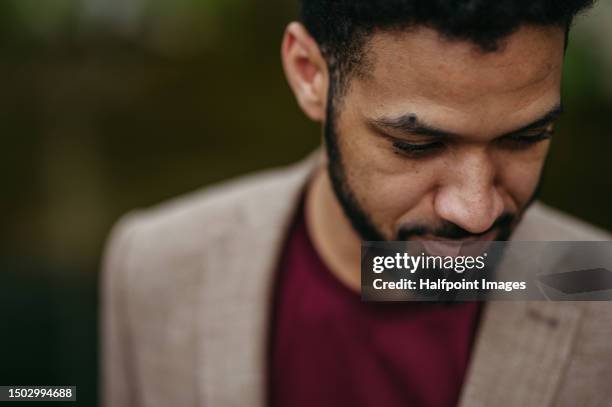 portrait of handsome multiracial man looking down. - face down stock-fotos und bilder