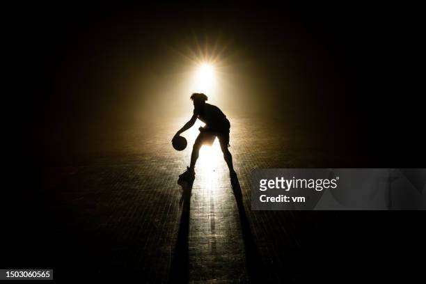 male basketball player silhouette dribbling ball - basketball competition stockfoto's en -beelden