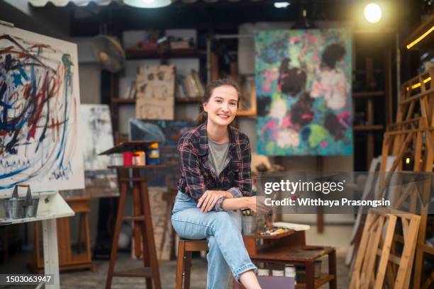 woman artist works on abstract acrylic painting in the art studio - east asian works of art specialist stock pictures, royalty-free photos & images