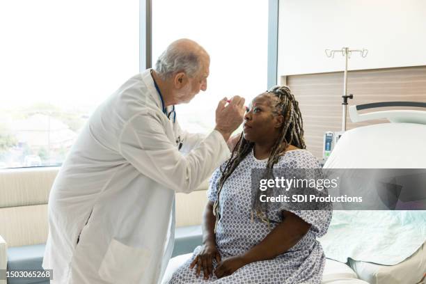 in er, senior doctor checks mature woman for concussion - brain damage stock pictures, royalty-free photos & images
