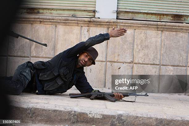 Member of the Syrian opposition gestures as they take position during fighting against forces loyal to President Bashar al-Assad in the disputed...