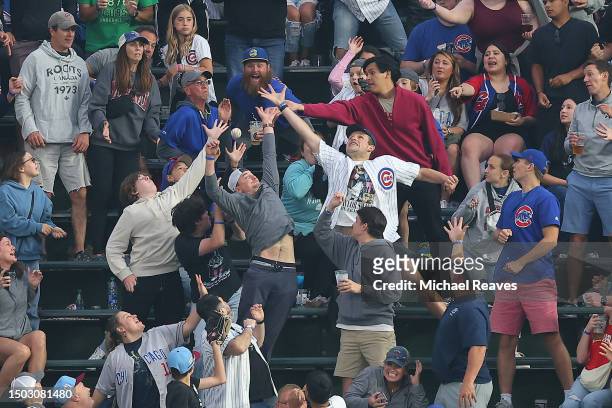 Fans catch a home run by Brandon Marsh of the Philadelphia Phillies during the fifth inning against the Chicago Cubs at Wrigley Field on June 27,...