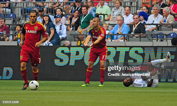 Dane Richards of the Vancouver Whitecaps grabs his ankle after a tackle from Chris Wingert of Real Salt lake, while his teammate Fabian Espindola...