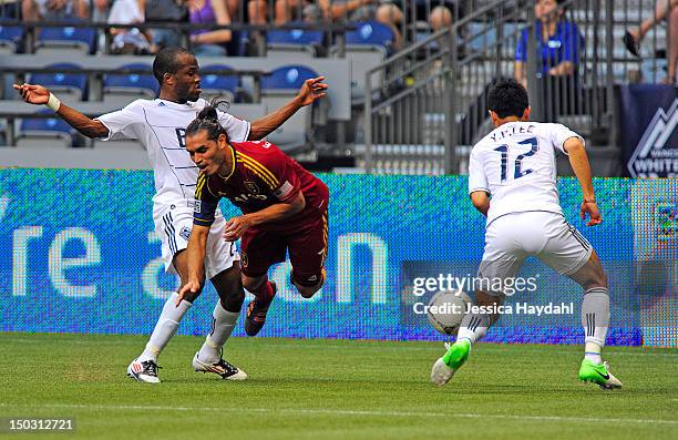Fabian Espindola of Real Salt Lake gets tripped up by Dane Richards of the Vancouver Whitecaps, while his teammate Lee Young-Pyo looks on at B.C....
