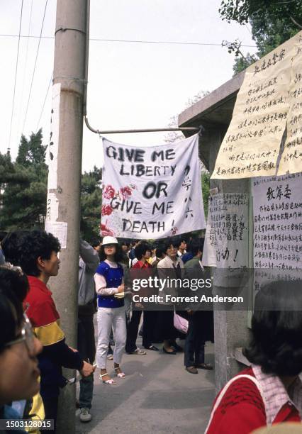 At Beijing University, people read pro-democracy posters, as well as banner that say , 'Give Me Liberty or Give Me Death,' Beijing, China, April 27,...