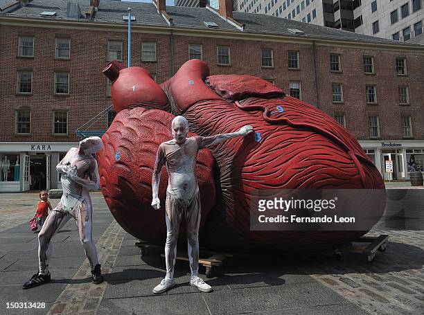 Two Bodies pose for pictures during "Bodies...The Exhibition" Unveiling of a Huge Heart Statue at South Street Seaport on August 15, 2012 in New York...
