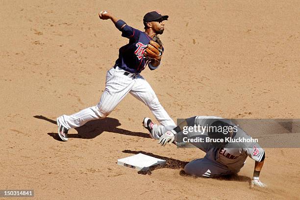 Alexi Casilla of the Minnesota Twins forces out Carlos Santana of the Cleveland Indians and throws to first base on July 29, 2012 at Target Field in...