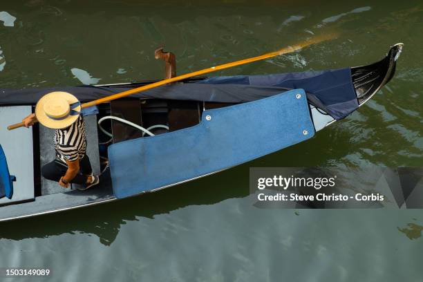 Gondolier navigates his gondola in the canals of Venice, on August 17 in Venice, Italy.