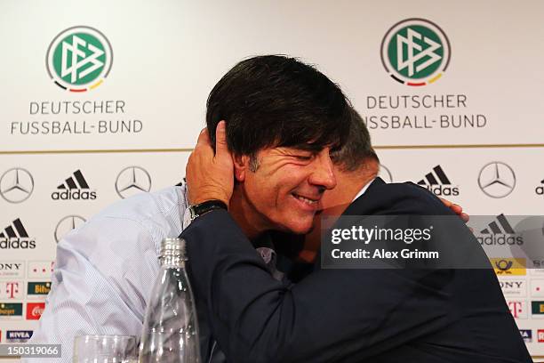 Head coach Joachim Loew of Germany and DFB press officer Harald Stenger hug after Stenger's last press conference following the international...