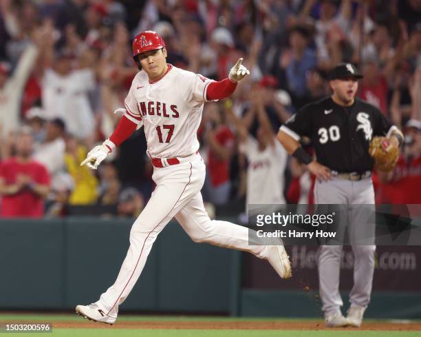 Shohei Ohtani of the Los Angeles Angels celebrates his solo homerun running past Jake Burger of the Chicago White Sox, to take a 3-1 lead over the...