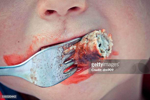 boy eating piece of sausage with fork - sausage stock-fotos und bilder