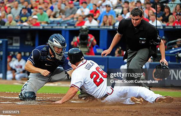 Dan Uggla of the Atlanta Braves is tagged out by Nick Hundley of the San Diego Padres at Turner Field on August 15, 2012 in Atlanta, Georgia.