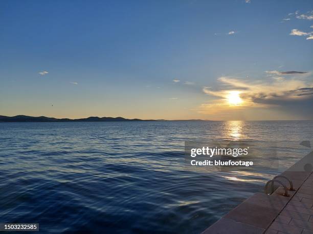 people enjoy the famous sea organ in zadar, croatia - bluefootage fotografías e imágenes de stock