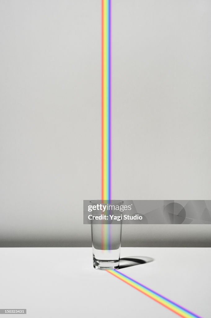The cup filled with water and a rainbow