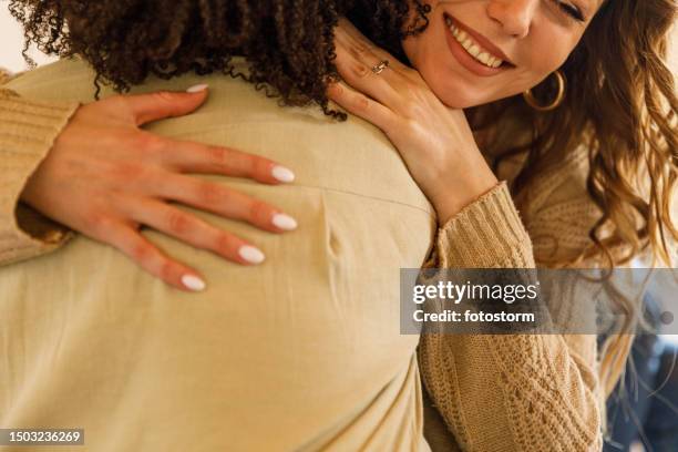 two girlfriends embracing after resolving a problem during a group therapy session - abraço imagens e fotografias de stock