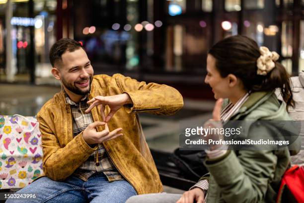 young couple having a conversation in sign language - sign stockfoto's en -beelden