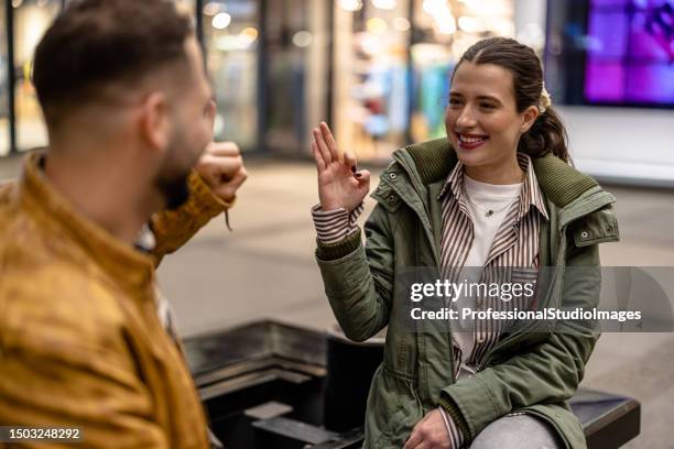 young couple enjoying a conversation on a peaceful night - woman fingers in ears stock pictures, royalty-free photos & images