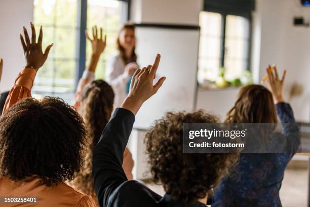 businesswoman writing on whiteboard while holding a presentation for a group of business people - q and a stock pictures, royalty-free photos & images