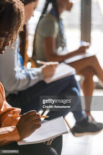 business people taking notes during a presentation or a seminar - leadership development vertical stock pictures, royalty-free photos & images