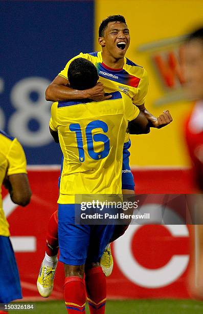 Jefferson Montero of Ecuador leaps into the arms of teammate Antonio Valencia as they celebrate a goal by Montero in the second half of a soccer game...