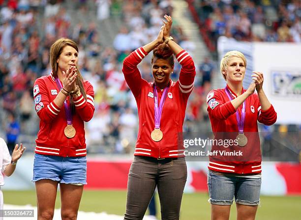 Sophie Schmidt, Karina LeBlanc and Emily Zurrer of Canada's Olympic bronze-medal winning soccer team are honored before the MLS game between FC...