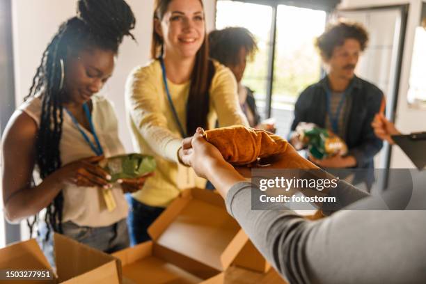 group of volunteers preparing donation boxes with clothes - pengainsamling bildbanksfoton och bilder