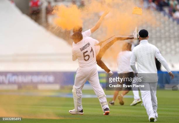 Jonny Bairstow of England tackles a "Just Stop Oil" pitch invader during Day One of the LV= Insurance Ashes 2nd Test match between England and...