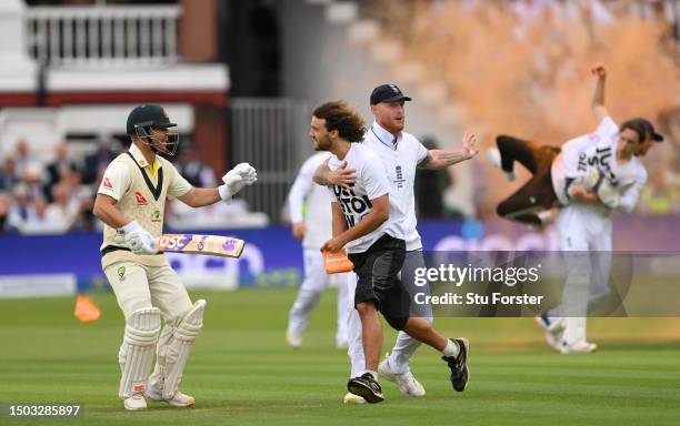 Ben Stokes of England and David Warner of Australia attempt to stop a "Just Stop Oil" protester as Jonny Bairstow of England tackles a "Just Stop...