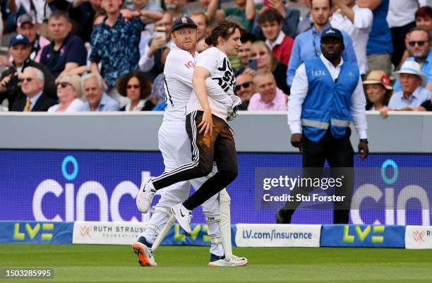 Jonny Bairstow of England removes a "Just Stop Oil" pitch invader during Day One of the LV= Insurance Ashes 2nd Test match between England and...