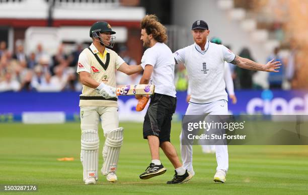 Ben Stokes of England and David Warner of Australia attempt to stop a "Just Stop Oil" protester during Day One of the LV= Insurance Ashes 2nd Test...