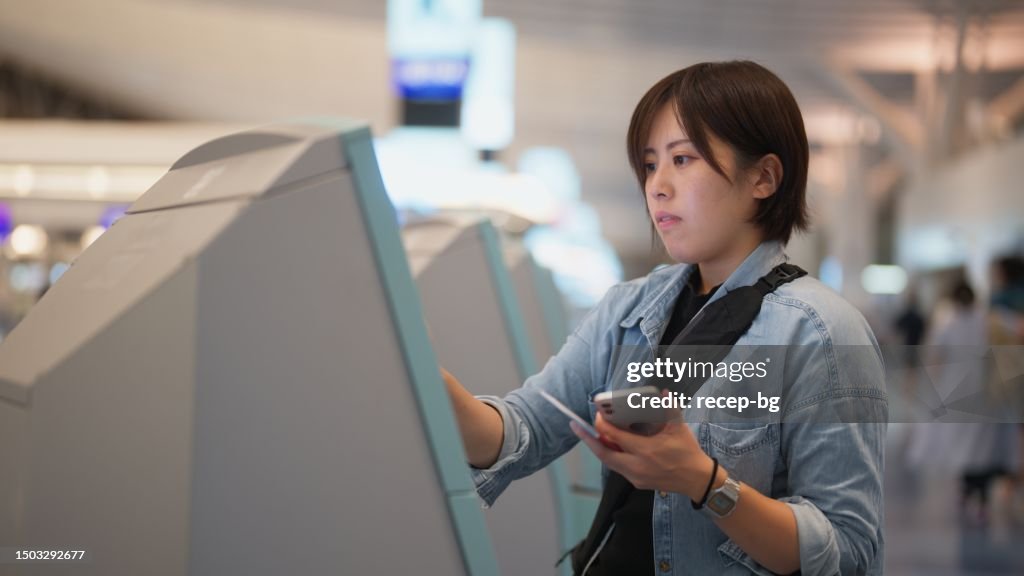 Automated Check In Counter Female Tourist Using Automated Self Checkin Counter In Airport High-Res ...