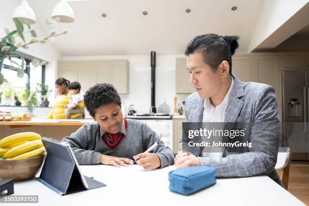 asian father helping multiracial son with homework - korean ethnicity stock pictures, royalty-free photos & images