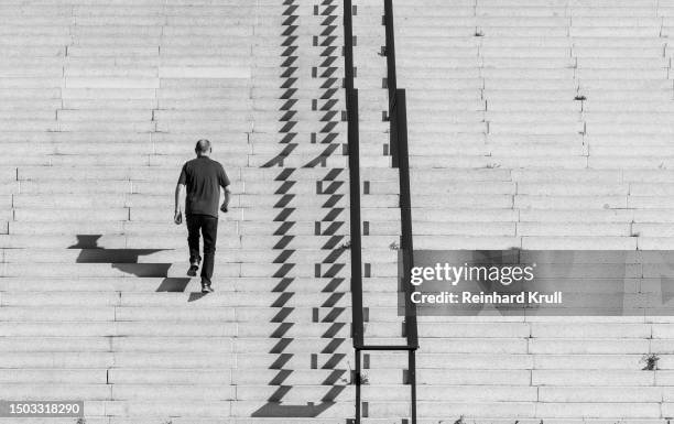 rear view of a man climbing the stairs - black and white stairs stock pictures, royalty-free photos & images