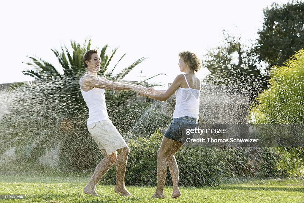 A couple playing with water outdoors