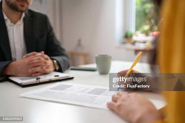 unrecognizable woman signing the contract, during a meeting with a male real estate agent - lease agreement stock pictures, royalty-free photos & images